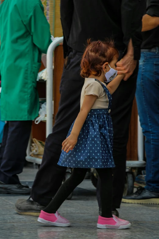 small child wearing pink shoes walking in the rain