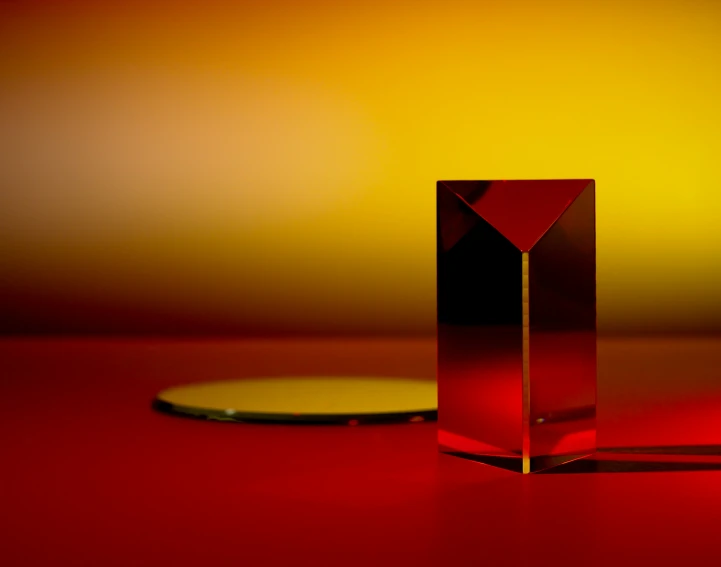 a square shaped crystal object standing on a red surface