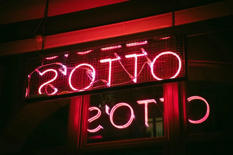 a neon sign hanging off the side of a building