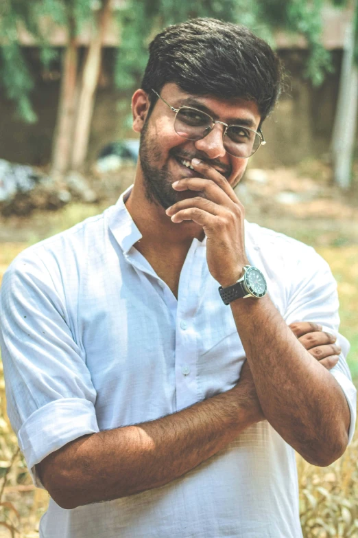 a young man with glasses and a watch is posing for the camera