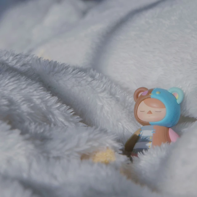 a small toy is laying on the blanket