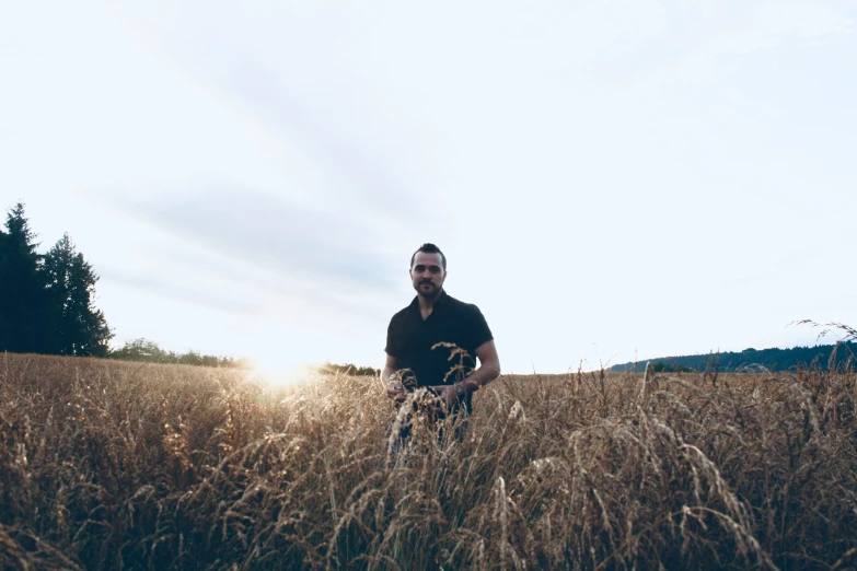 a man is standing in the tall grass