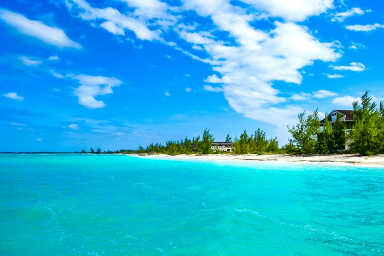 an empty island sits on the horizon with clear blue waters