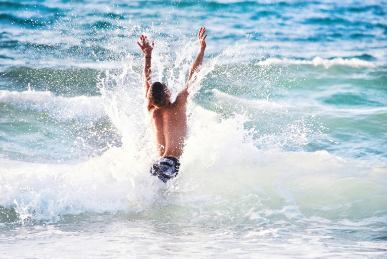 a boy stands on his surfboard while riding the waves in the ocean