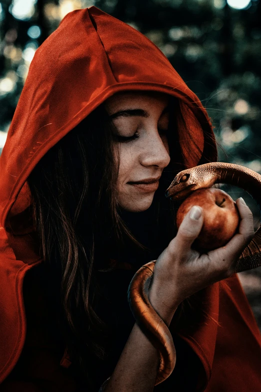 girl with red hood, holding an apple, in the woods