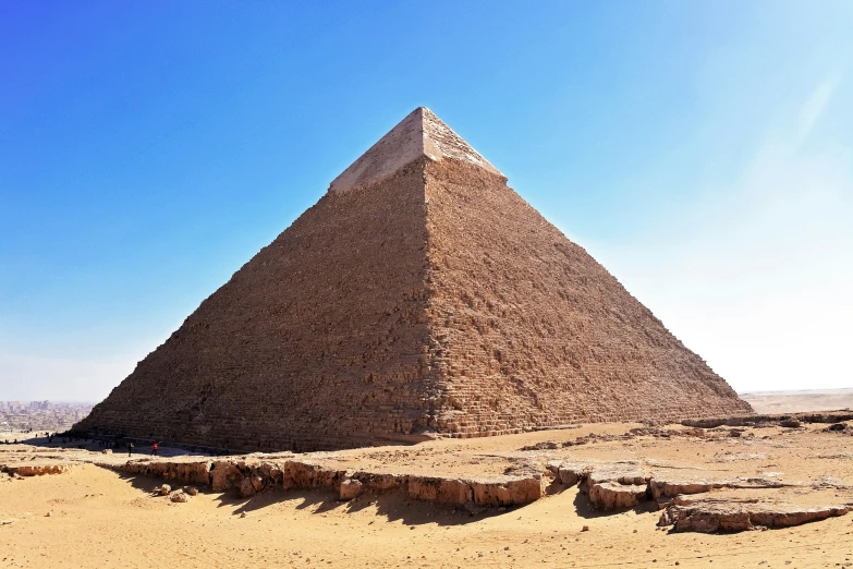 a large pyramid sitting on top of a sandy field