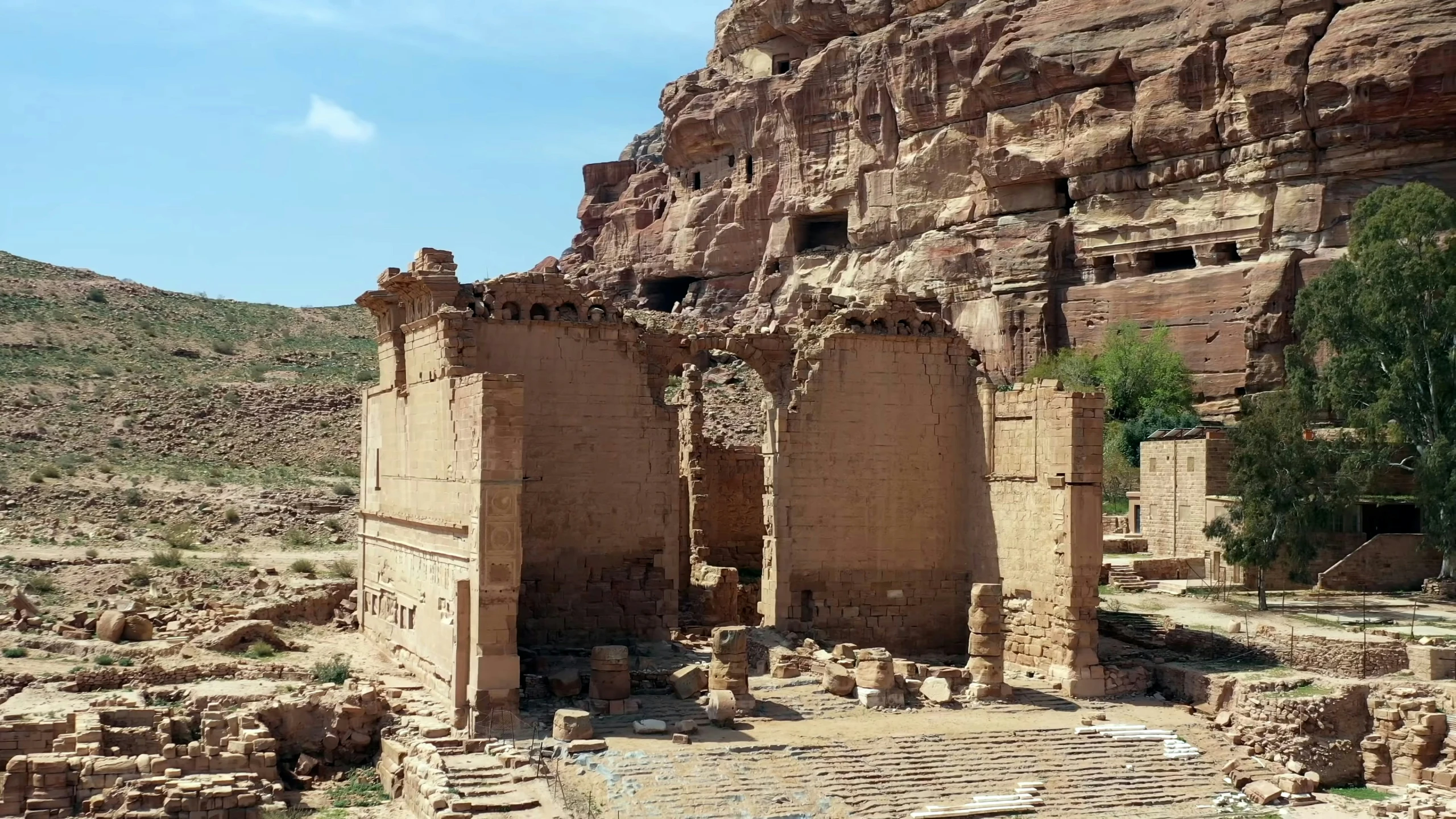 the ruins of some ancient buildings in front of a rocky mountain