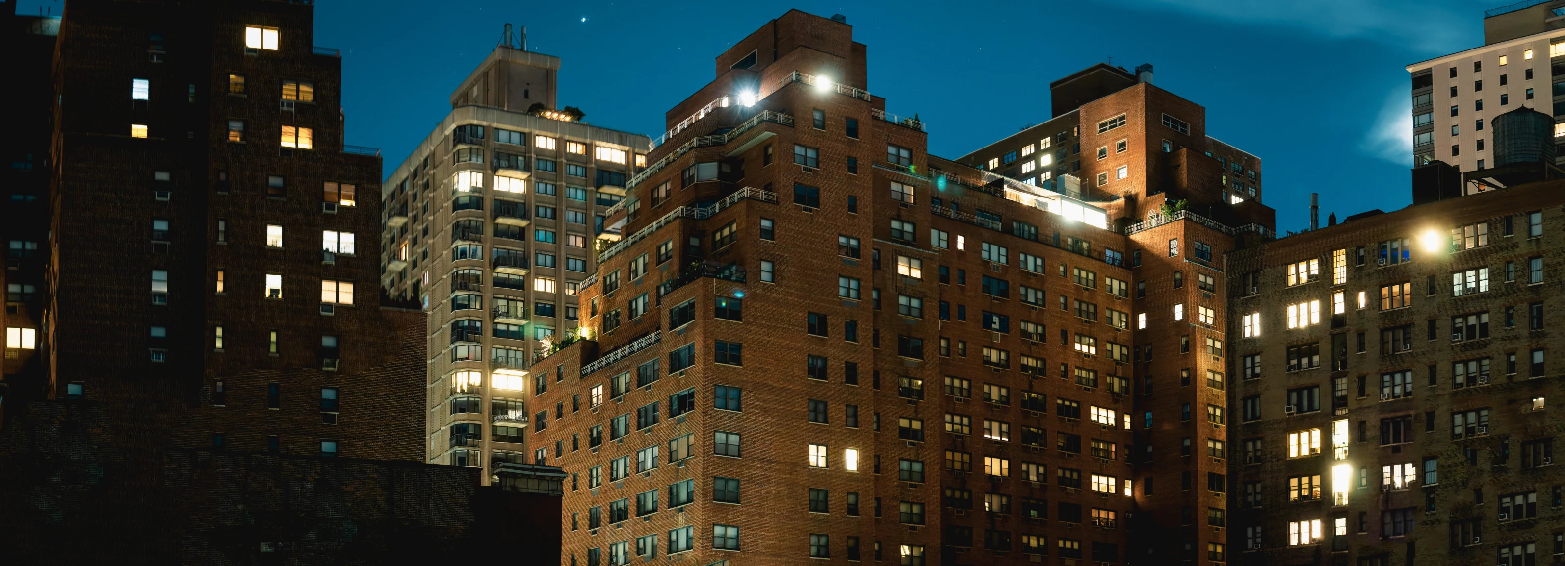 buildings all lit up at night while lights shine