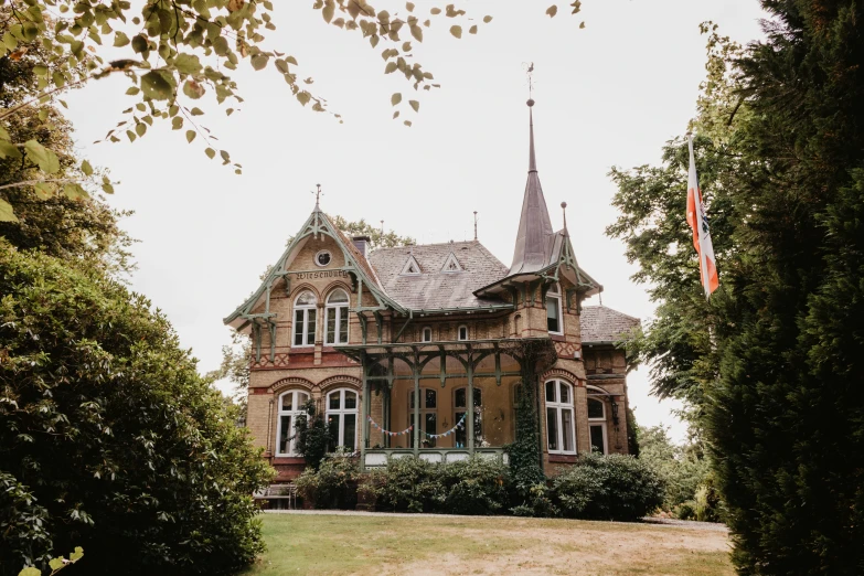 an old house that has some plants and trees on the front