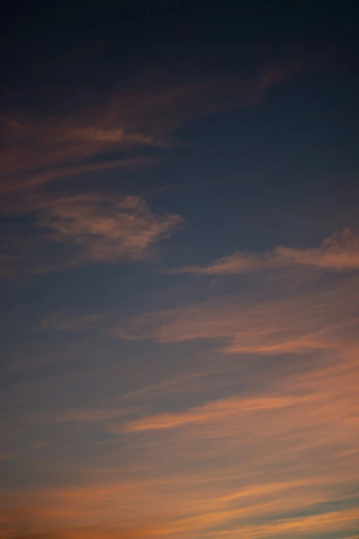 an airplane is flying low in the sky at sunset