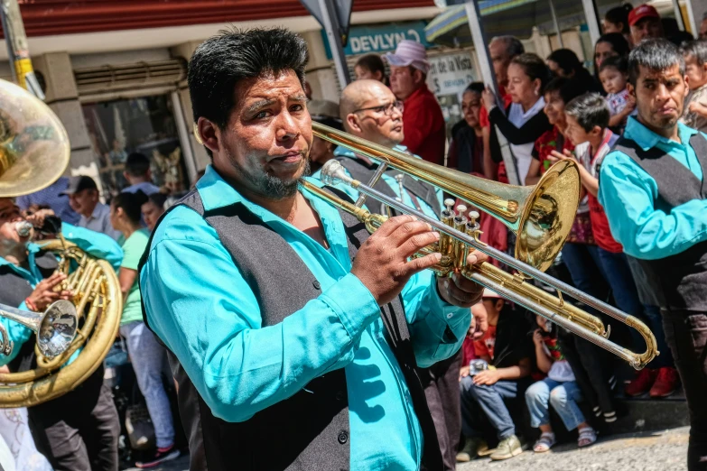 the man is playing his trumpet as other people watch