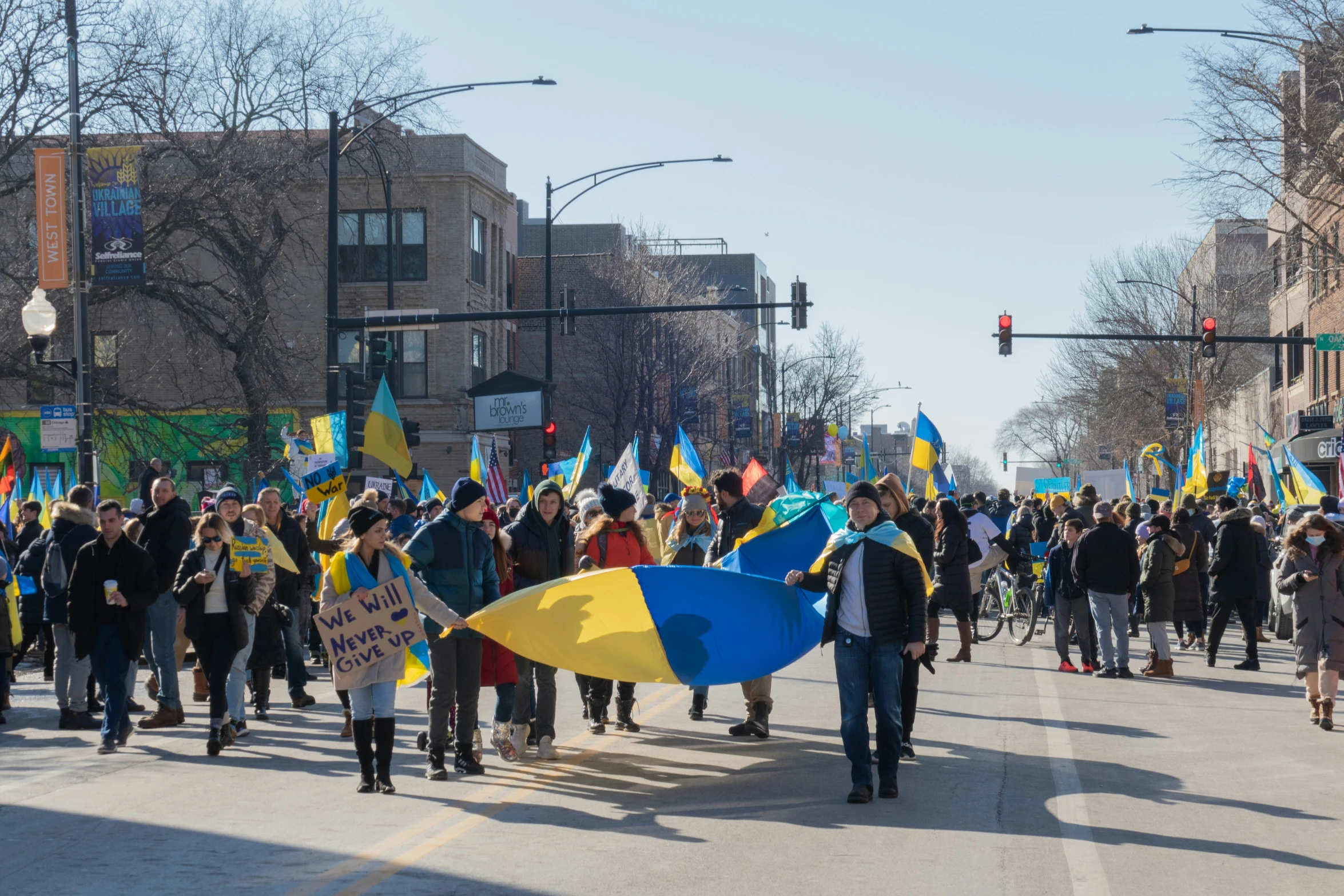 a number of people marching down a street carrying large items