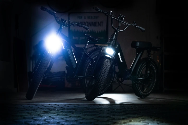 two bikes are parked in the dark outside