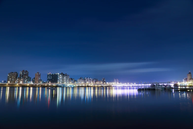 the city skyline shines brightly as the water reflects off its surface