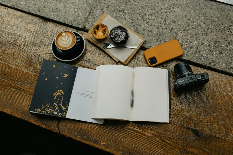 coffee and a book on the table near the camera