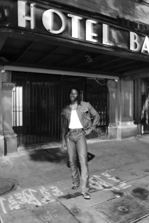 the man in a jean jacket is standing outside a el