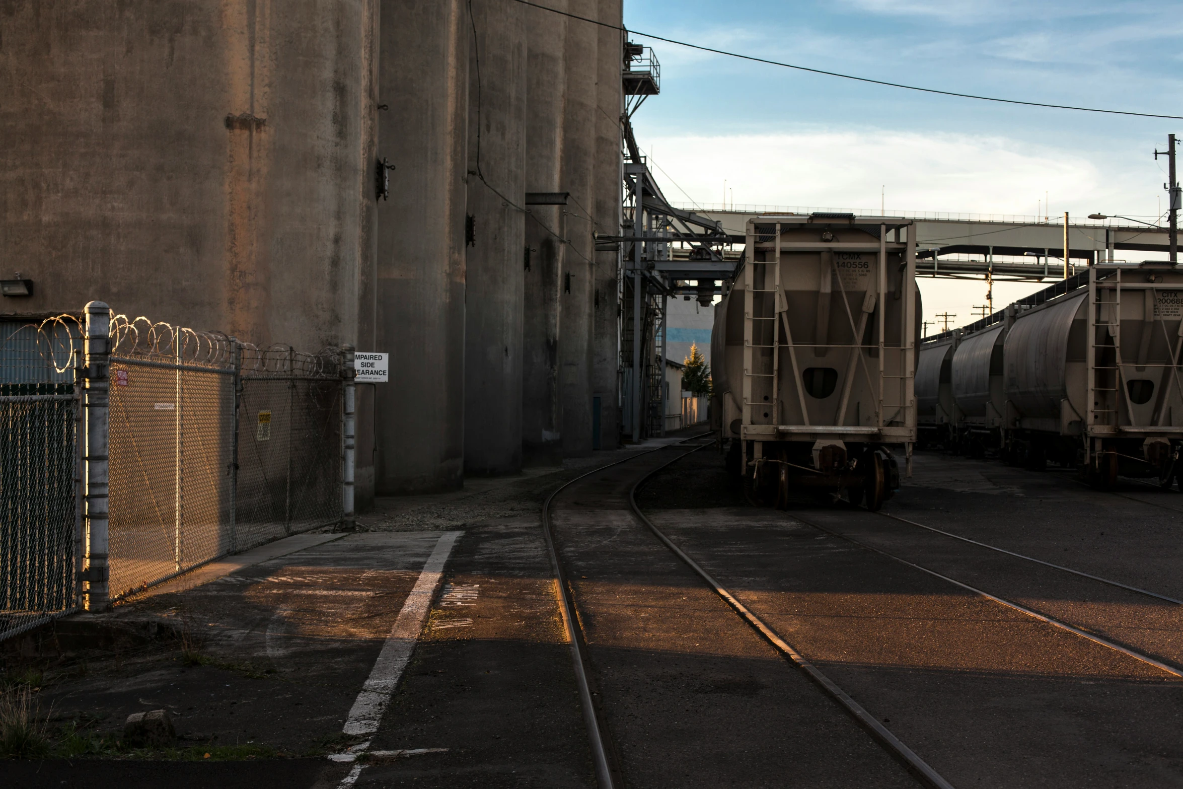 a train sitting on the tracks next to a concrete building