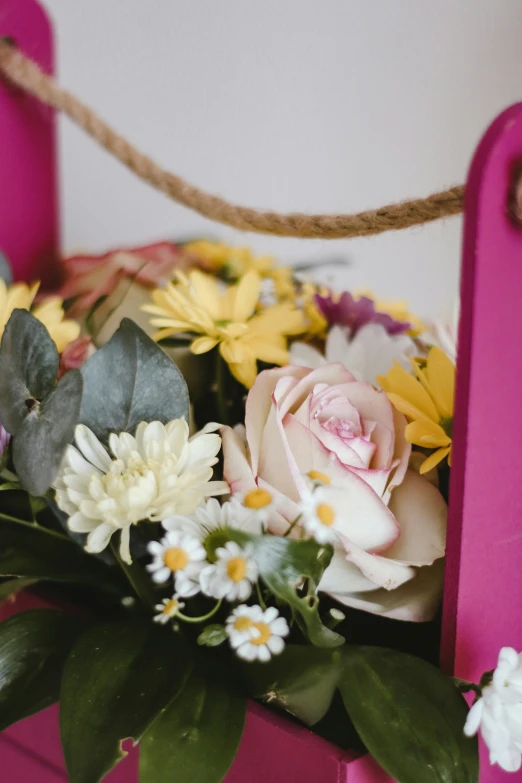 this is an arrangement of different flowers in a pink vase