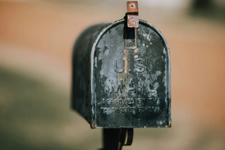 a large old metal mailbox is near an umbrella