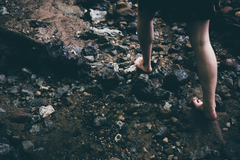 a person walking on rocks in the dirt