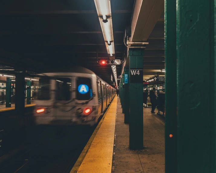 a subway train pulling into a station at night