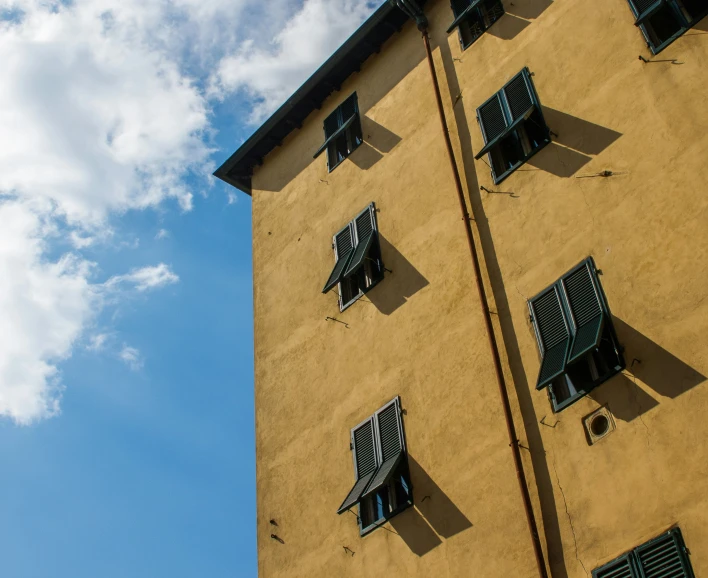 an unusual building with windows and black shutters