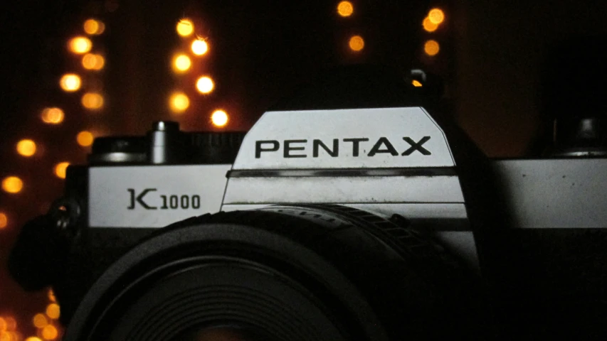 a closeup of a pentax camera with its flash on the side