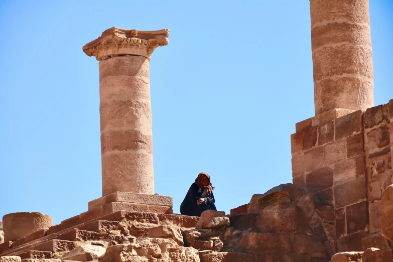 a woman taking a po next to some pillars