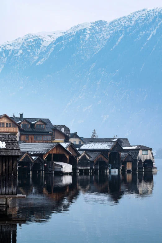 snow on mountains sit above the small wooden buildings