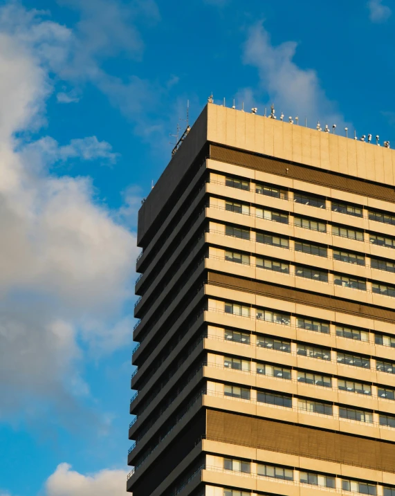 a large building with windows and sky in background