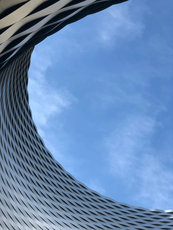 an artisticly shaped round building against a blue sky