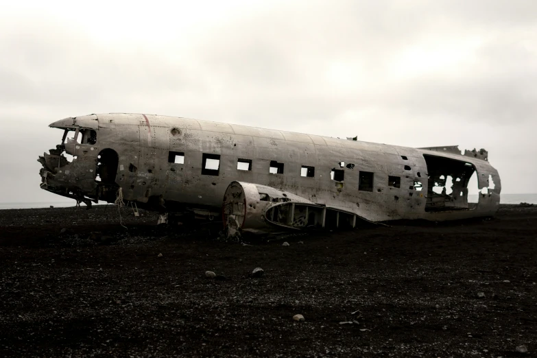 an old silver airplane sitting on top of a dry grass field