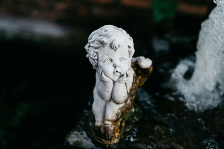 a statue of a little boy holding a piece of wood