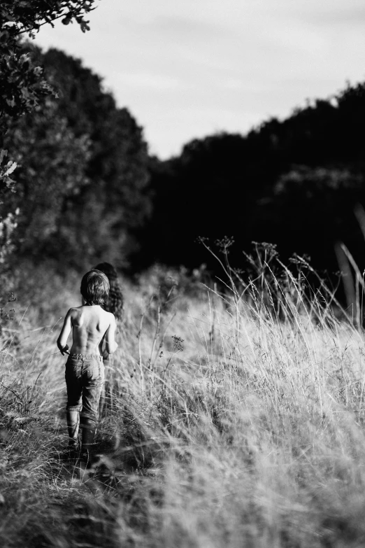 the small  boy is walking in the field