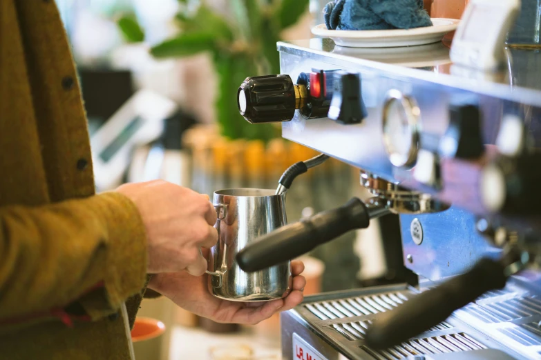 someone is pouring their coffee from the machine