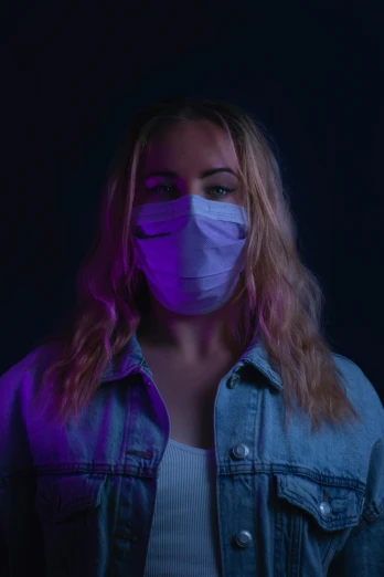 a girl is wearing a mask against a dark background