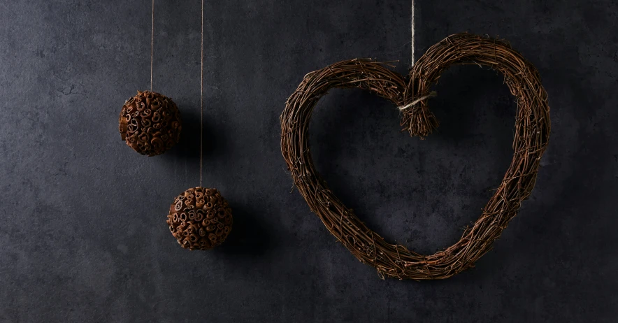 a heart shaped sculpture is shown next to three balls