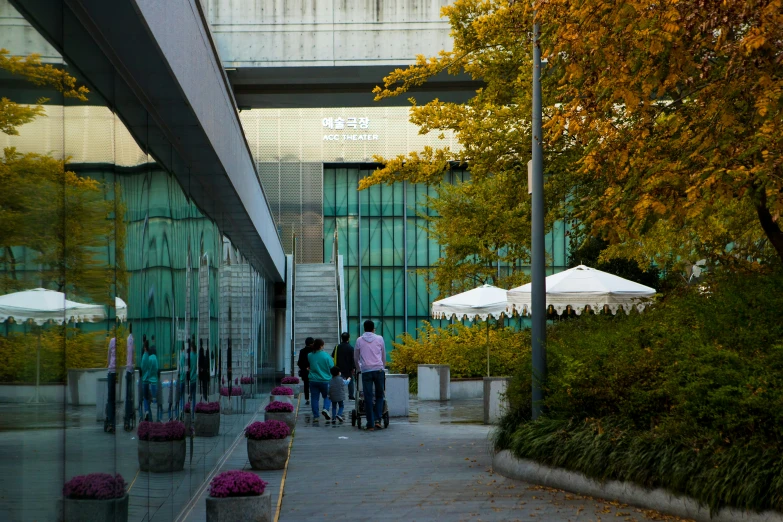 people walking down a sidewalk under an overpass