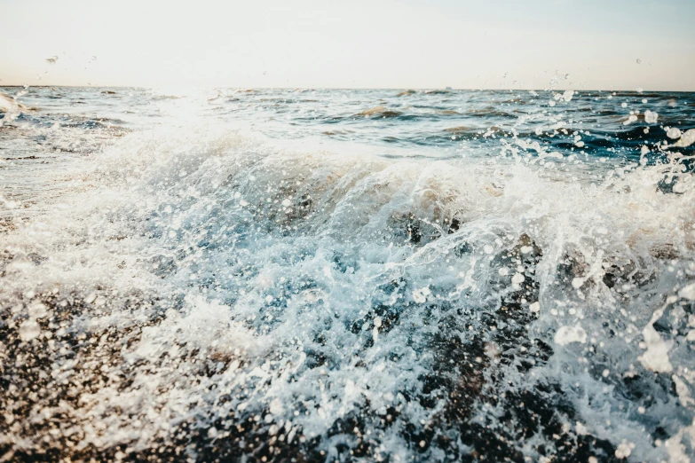 a blue ocean with a splashing ocean wave