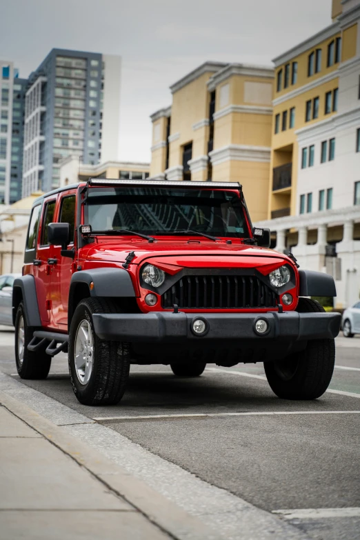 a red jeep parked next to tall buildings