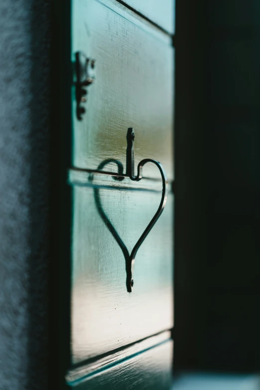 shadow cast on the wall with a heart shaped hook