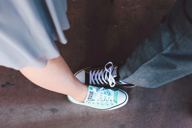 a person standing on the ground with their feet in someones shoes