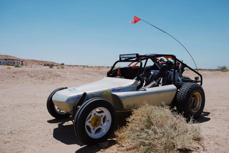 a dune buggy sitting in a barren area on a sunny day