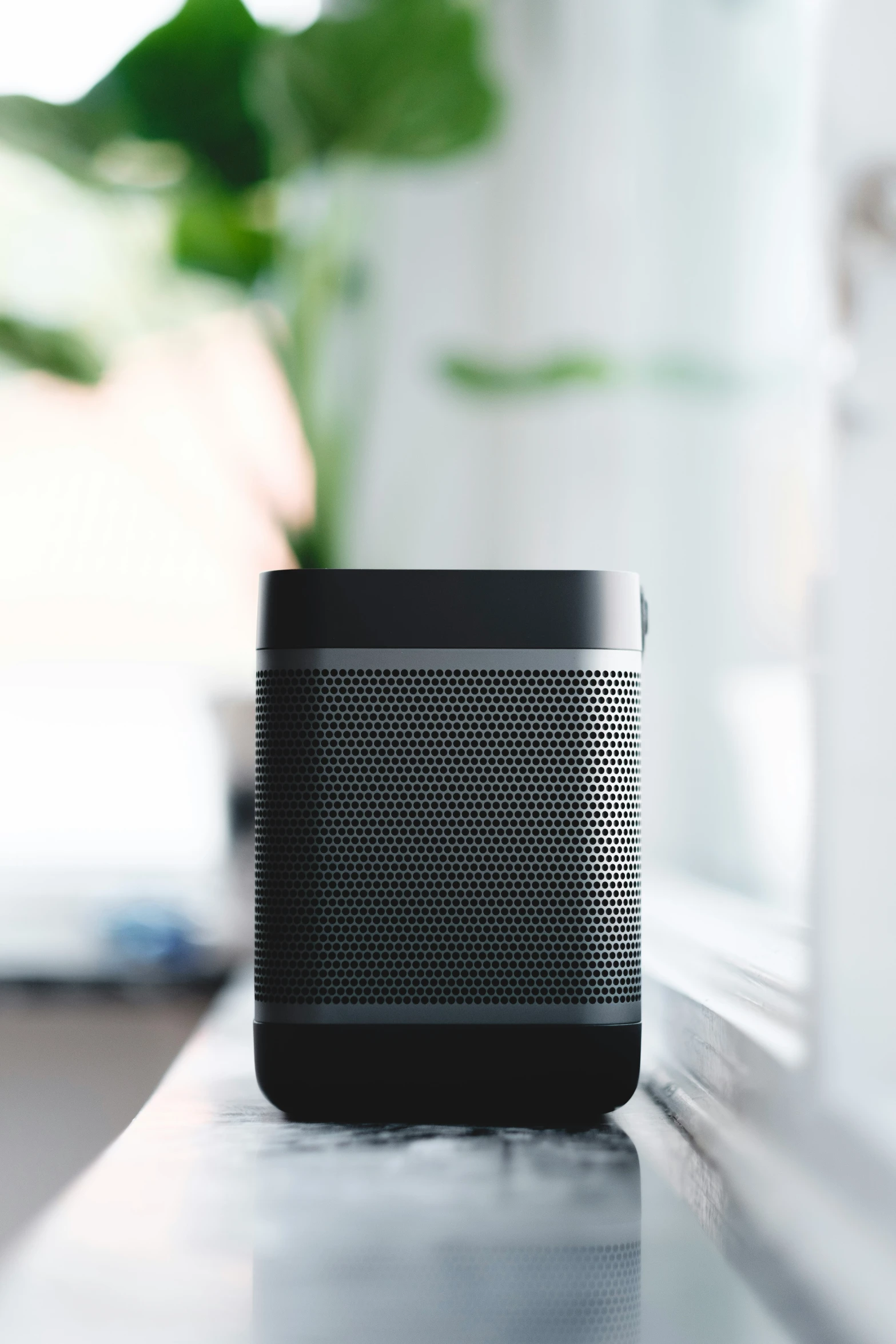 a black speaker on a table in a home office