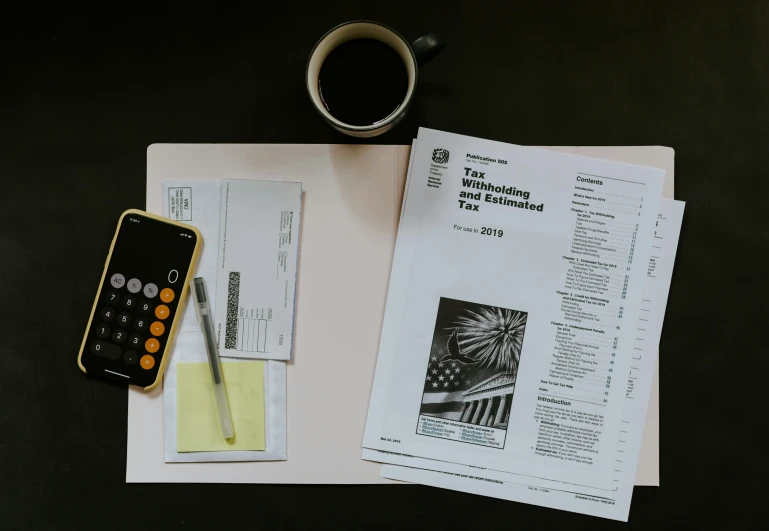 a pencil, calculator and pen sitting next to a paper