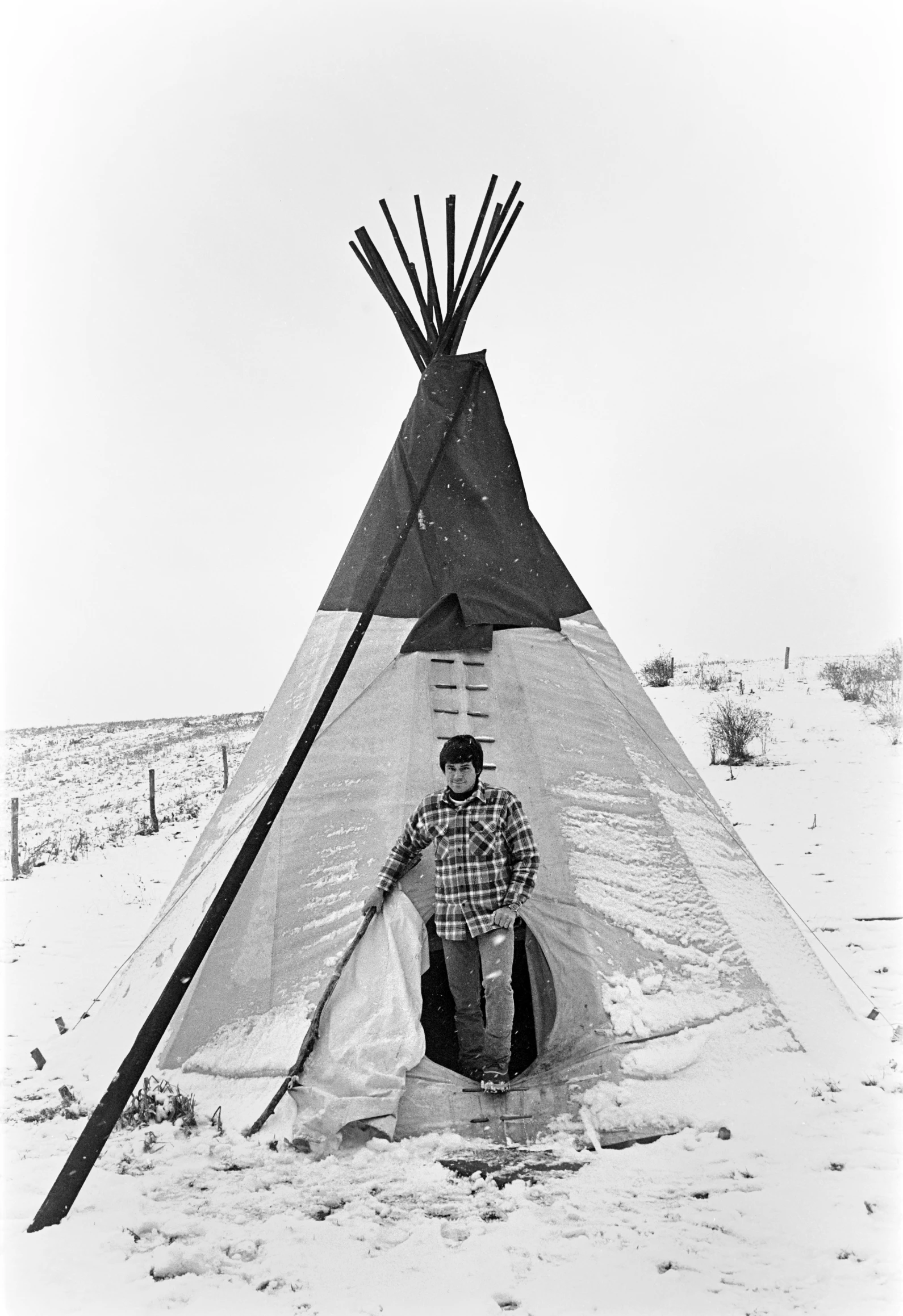 a person standing in front of a teepee