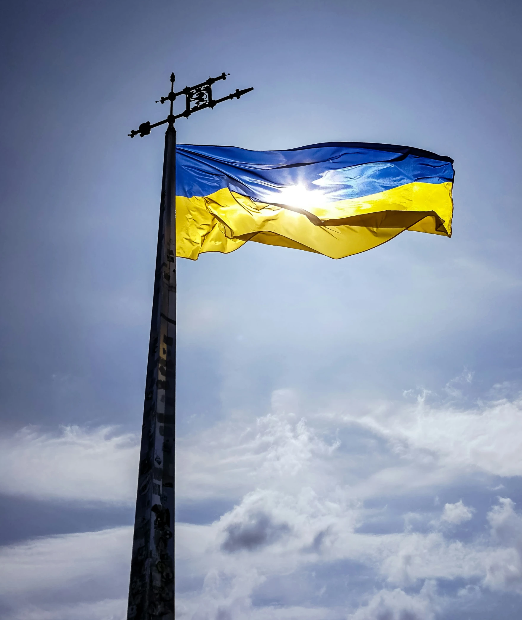 a blue and white flag is on top of a tall pole