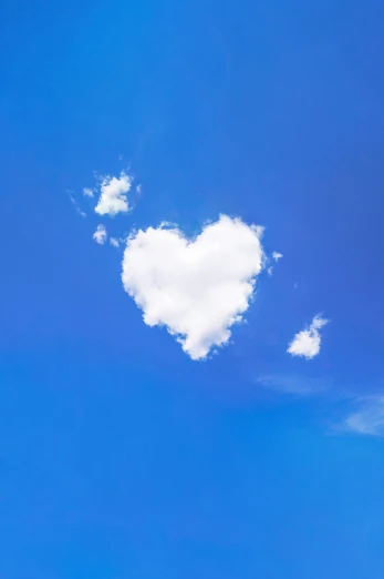 two planes fly past a big heart shaped cloud in the sky