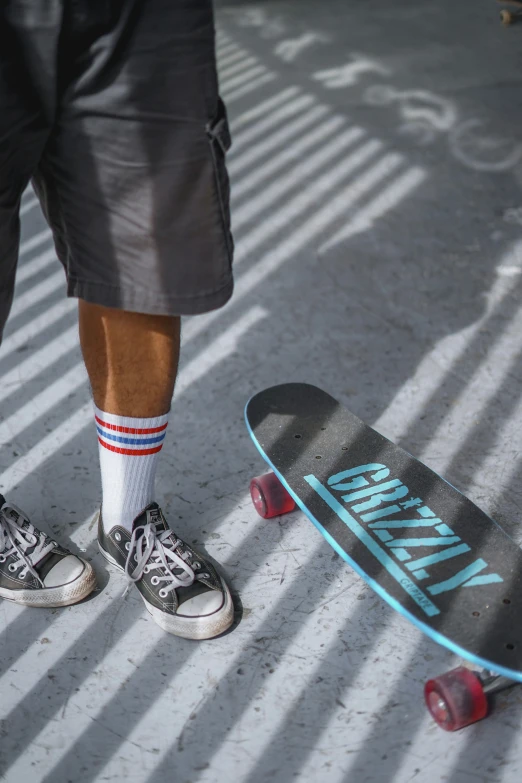 someone wearing shorts and socks is standing next to their skateboard