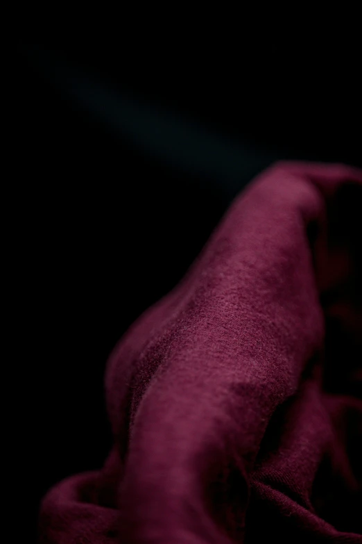 a purple pillow in the dark with a red blanket on it